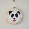Décoration murale. Cadre réalisé à la punchneedle représentant un panda tirant la langue. La langue est réalisée au crochet.