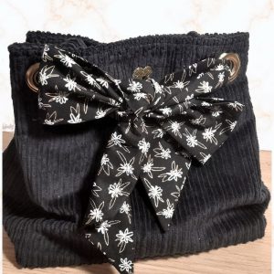 Sac seau en velours bleu nuit porté croisé par une chaine dorée. Fermeture par un bandeau en tissu coton noir, fleurs blanches.