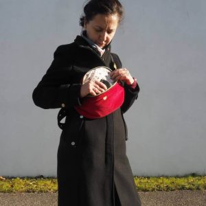 Sac banane Fanny, en velours côtelé rouge, porté une sur un manteau noir, permettant de réhausser une tenue