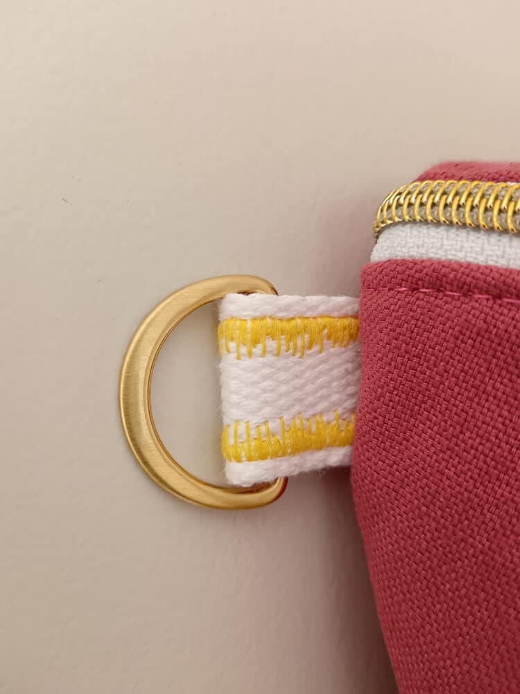 Sac banane "Les 90's"rose avec empiècement jaune. Zoom sur l'attache de la bandoulière.