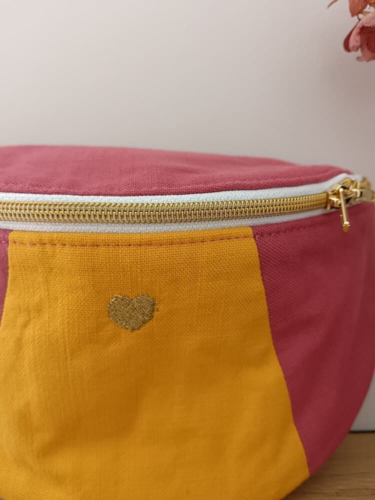 Sac banane "Les 90's"rose avec empiècement jaune. Zoom sur la broderie coeur.