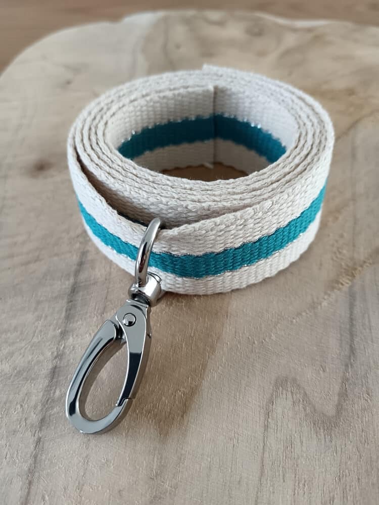 Bandoulières, anses réglables. Coloris : beige, turquoise, liserés dorés Bouclerie argentée.