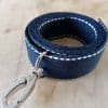 Bandoulières, anses réglables. Coloris : bleu marine, liserés blancs Bouclerie argentée.