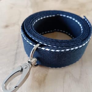 Bandoulières, anses réglables. Coloris : bleu marine, liserés blancs Bouclerie argentée.