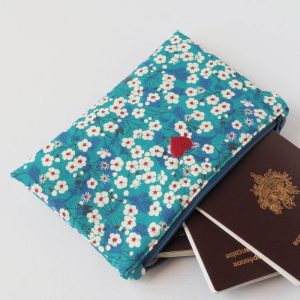 Pochette en liberty bleu fleurs blanches et rouge de taille S - Présenté avec des passeports.