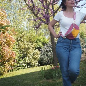 Sac banane 90's rose avec empiècement jaune porté sur un jean et haut blanc