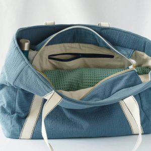 Sac cabas en double gaze de couleur bleu orage, avec fermeture par zip. Vue sur la doublure et la poche intérieure zipée