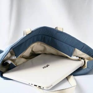 Sac cabas en double gaze de couleur bleu orage, avec fermeture par zip contenant un ordinateur portable.
