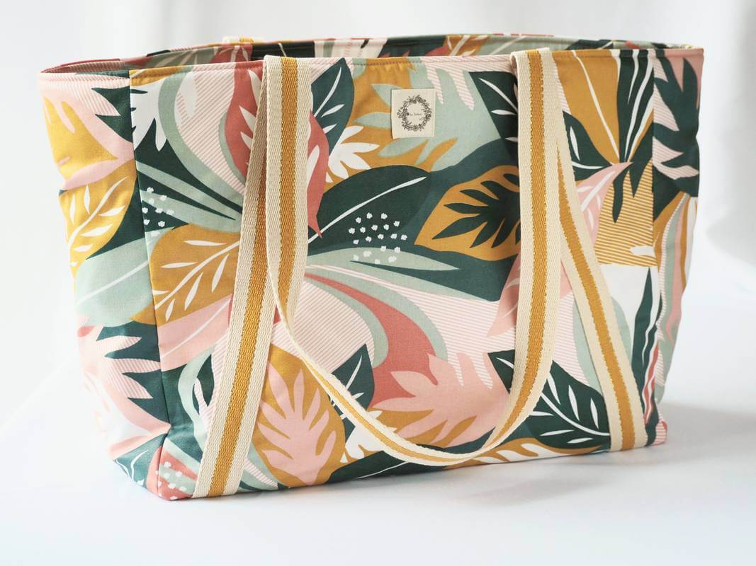Sac cabas en coton enduit, de motif tropical multicolor (rose, vert, moutarde,...), avec fermeture par zip. Vue de dos avec le logo by Zarboo.