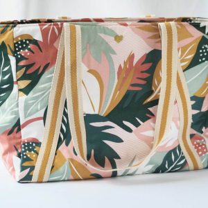 Sac cabas en coton enduit, de motif tropical multicolor (rose, vert, moutarde,...), avec fermeture par zip. Vue de devant avec la broderie coeur.