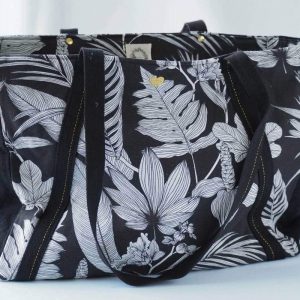 Sac cabas noir à motif tropical de grande contenance, avec sa broderie coeur dorée, vu de devant.